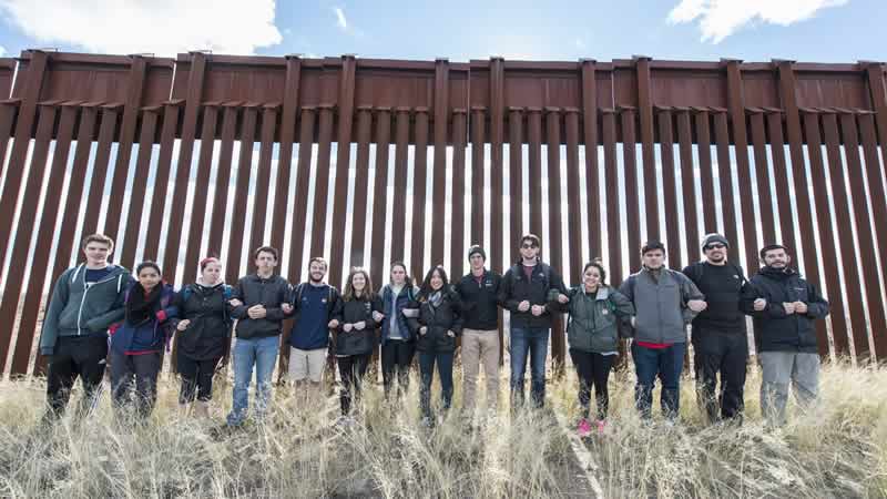 Team members in front of wall