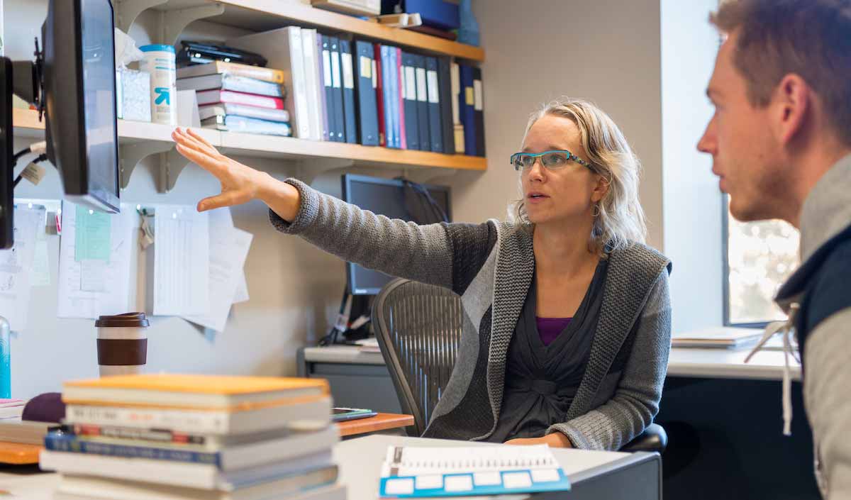 Professor Abigail Wozniak meets with a student in her office.