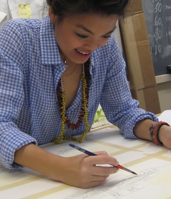 Architecture student Larissa Esmilla, '11 draws on a large sheet of white paper