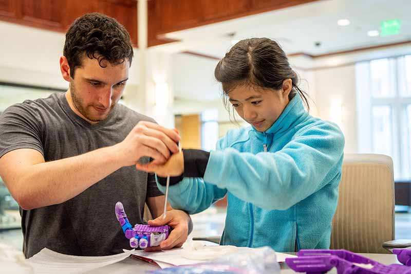 Tori gets help screwing in the last screw of her prosthetic hands.