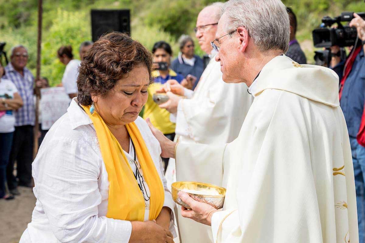 Father Jenkins serves the Eurcharist to a mother.