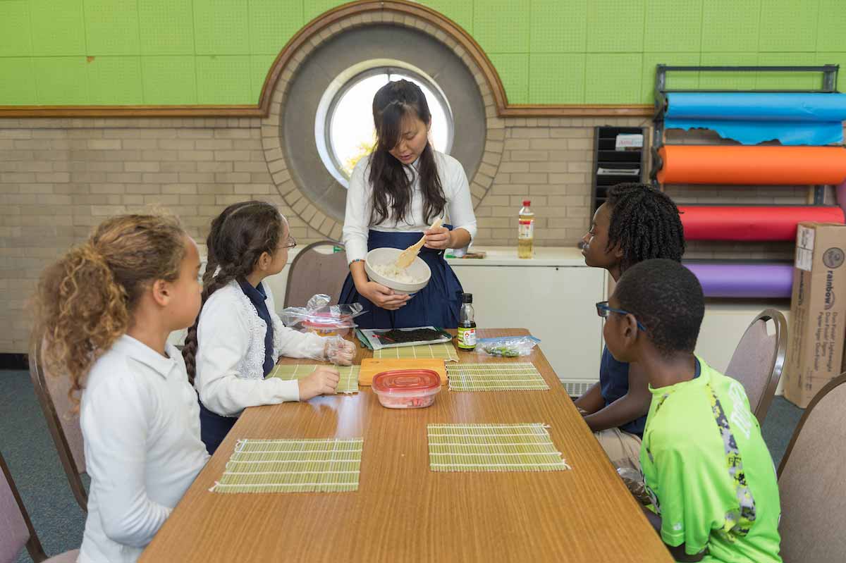 Heemang Kim shares part of her culture with a fourth-grade class as they make their own sushi rolls