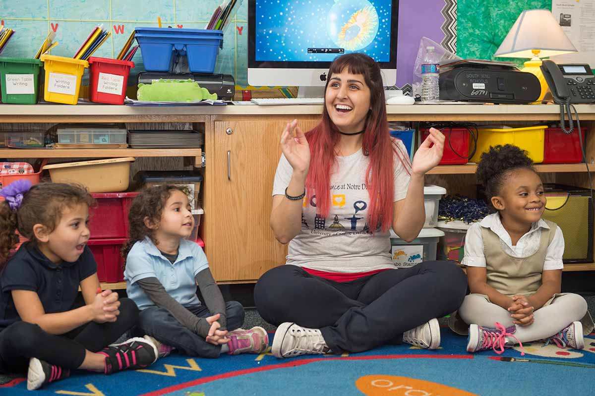 Kindergartners clap along as Anna Paula Cury teaches the song 'Bate O Sino,' Portuguese for 'Jingle Bells,' in the classroom.