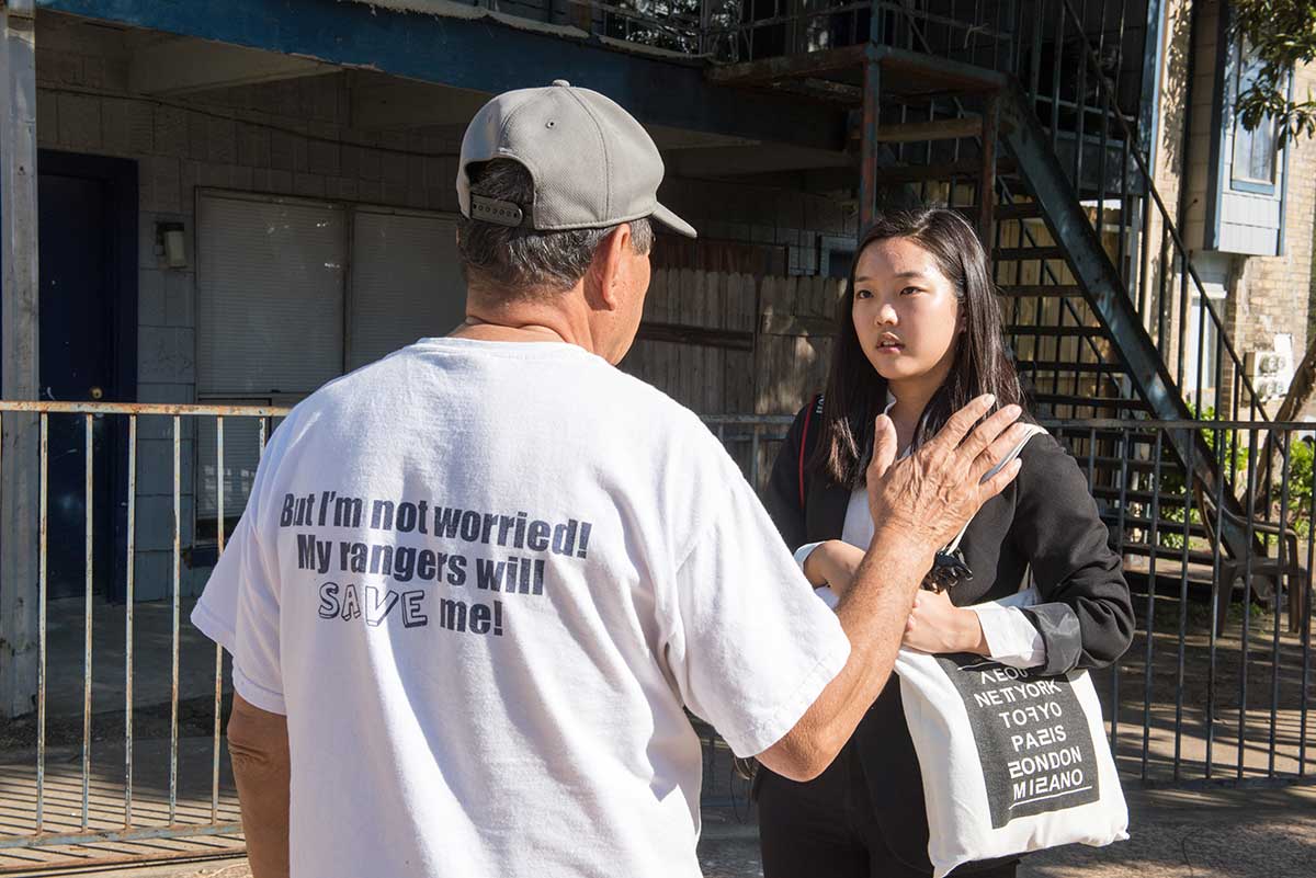 Student journalist Alex Park interviews a resident at Rockport Apartments, where many people moved out after flooding from Hurricane Harvey.