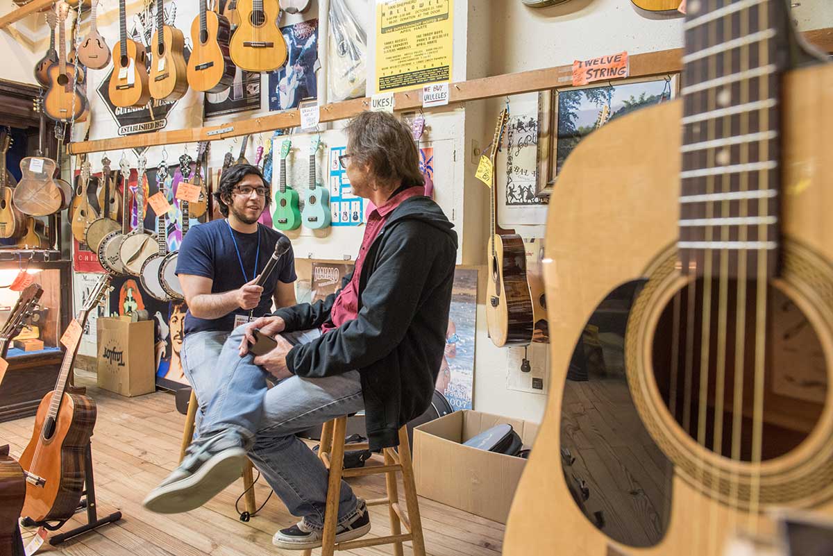Carlos De Loera interviews an employee at Rockin' Robin Guitars & Music store.