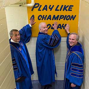 May 15, 2016; University of Notre Dame president Rev. John Jenkins, C.S.C. and Laetare Medal recipients, John Boehner, former Speaker of the House and Vice President Joe Biden, touch the Play Like a Champion sign on their way out of the locker room for the 2016 Commencement Ceremony at Notre Dame Stadium. (Photo by Barbara Johnston/University of Notre Dame)