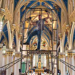 August 1, 2016; Joshua Wood, a professional rigger from Organ Clearing House of Charlestown, Massachusetts, locks in a section of scaffolding in front of the choir loft in the Basilica of the Sacred Heart. (Photo by Barbara Johnston)