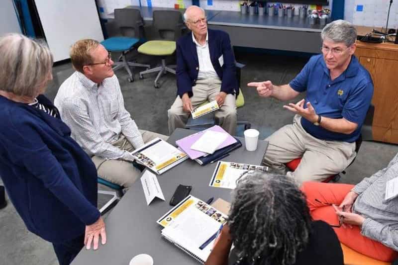 A group of older students work together around a table.