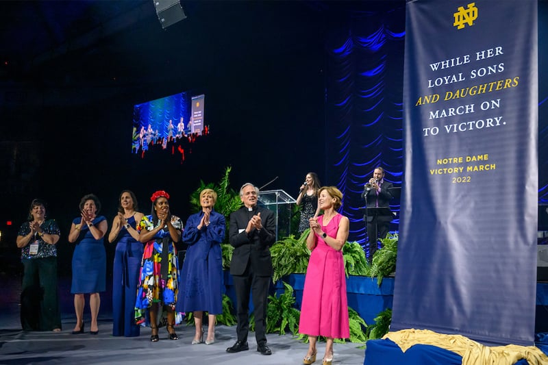 A banner is presented on stage showing new lyrics of the Notre Dame fight song.