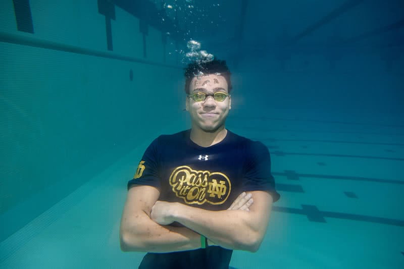 Underwater photo of a student crossing his arms with swimmer's goggles on