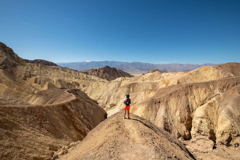 Student standing atop a large mound in the Golden Canyon badlands.