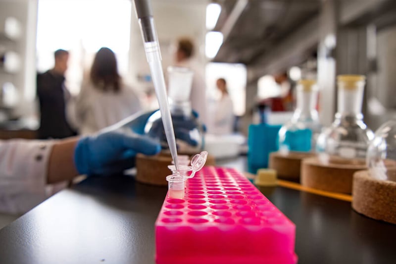 A researcher transfers liquid to vials for procedure