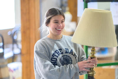 A woman carries a lamp.