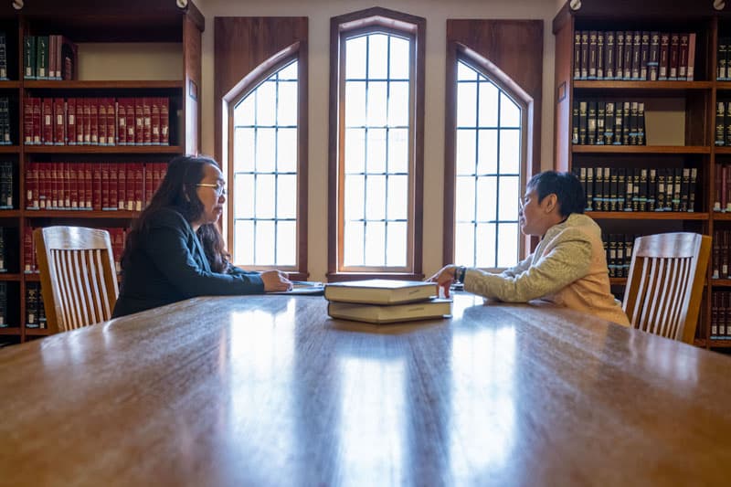 Professor Diane Desierto sits in the Law Library with Nobel Peace Prize Laureate Maria Ressa.