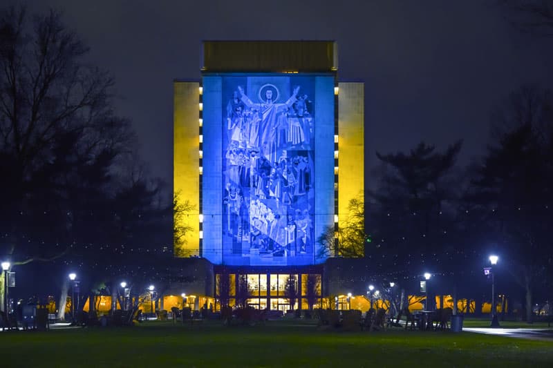 The Hesburgh Library Word of Life Mural is lit in the colors of the Ukrainian flag in solidarity with the people of Ukraine.