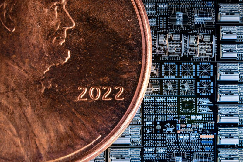 A penny next to a tiny computer wafer. The chips also contain tiny images of the Notre Dame Monogram and Leprechaun, images of the Dome and Basilica, and quotes.