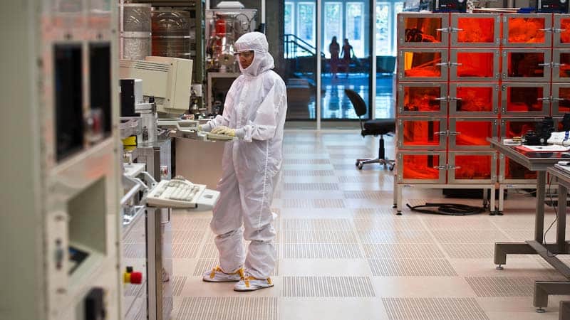 A woman wearing full protective gear works in the cleanroom.