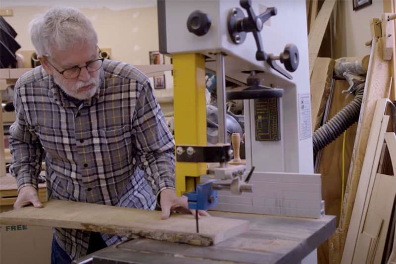 Doormaker Verlin Miller using a band saw to cut wood.