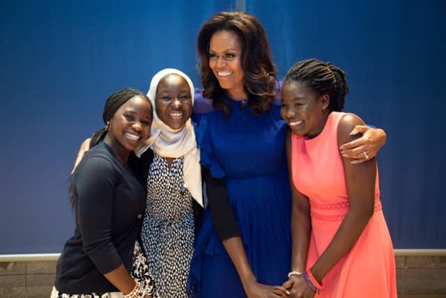 3 girls standing and embracing with Michelle Obama
