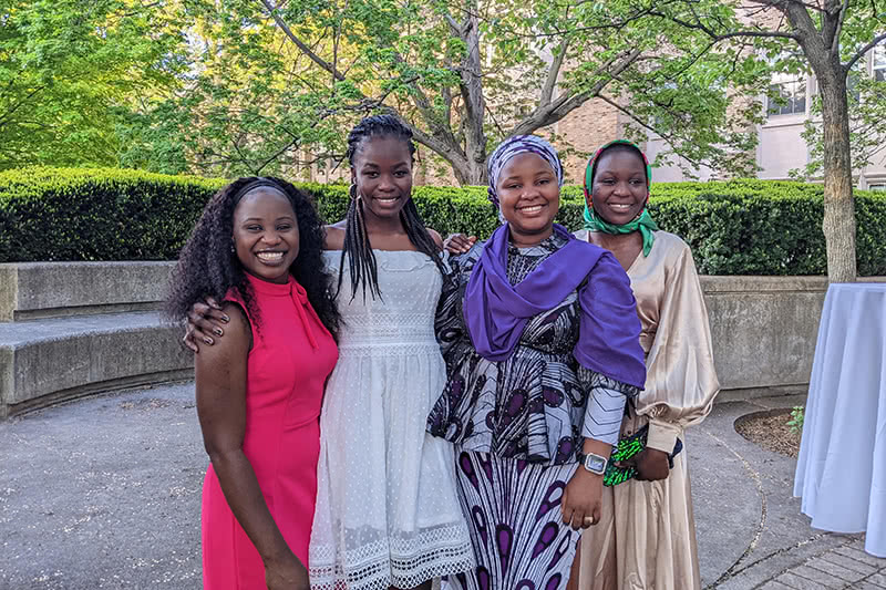 All 4 girls standing embraced on Notre Dame's campus