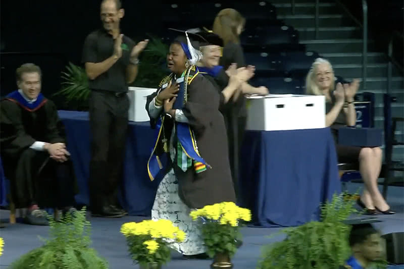 Laila Ibrahim walking across the stage to accept her diploma