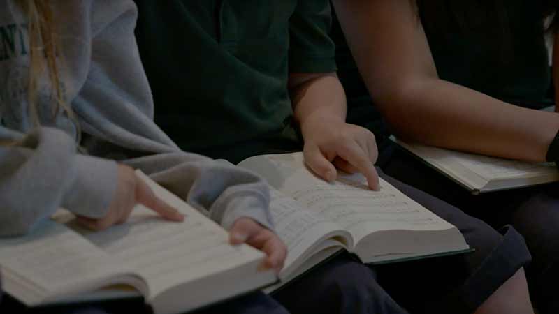 A close-up of people holding hymnals