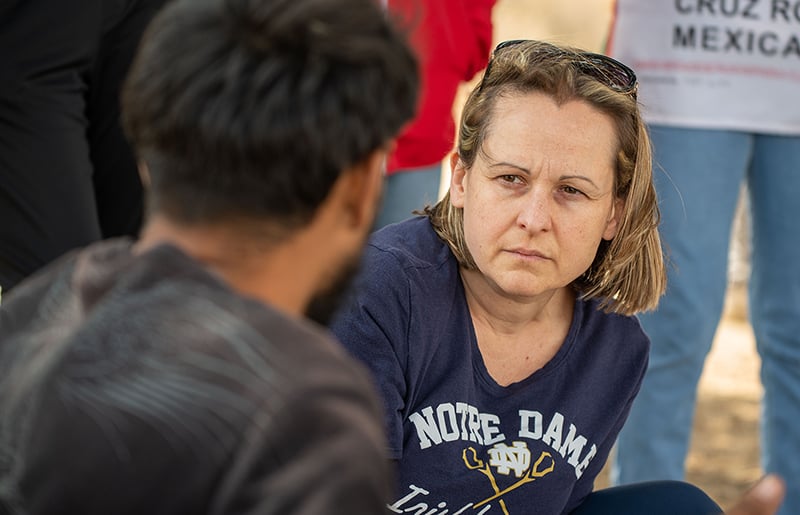 Professor Dziadula intensely listens to a migrant tell their story.