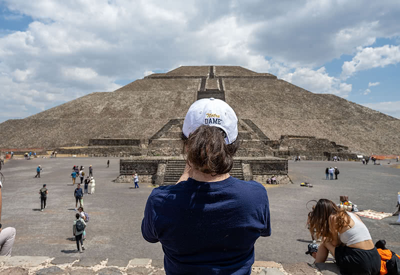 Student taking a photo with her phone of the Teotihuacan ruins.