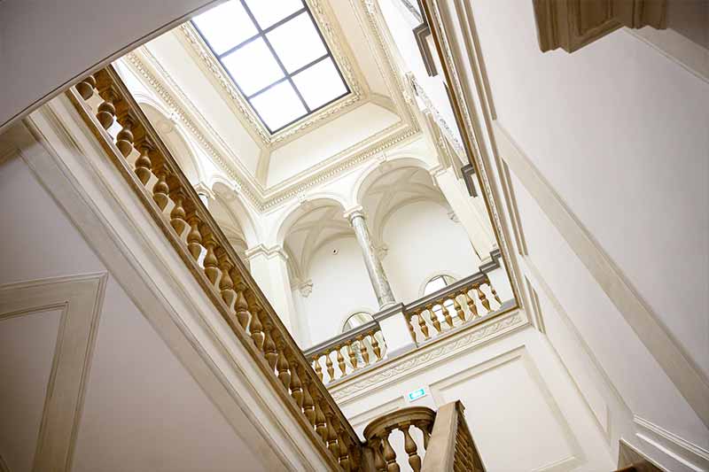 Inside the Villa in Rome looking up a bright stairwell.