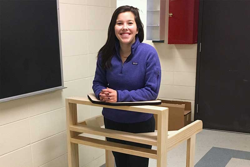 Marissa Koscielski standing with support from  a wooden walker.