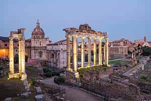 The Roman Forum at dusk, illuminated by light.