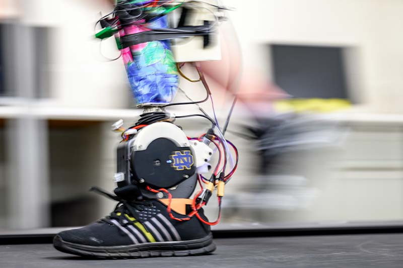 A slightly blurred moving powered prosthetic ankle mimics the movement of a real foot.