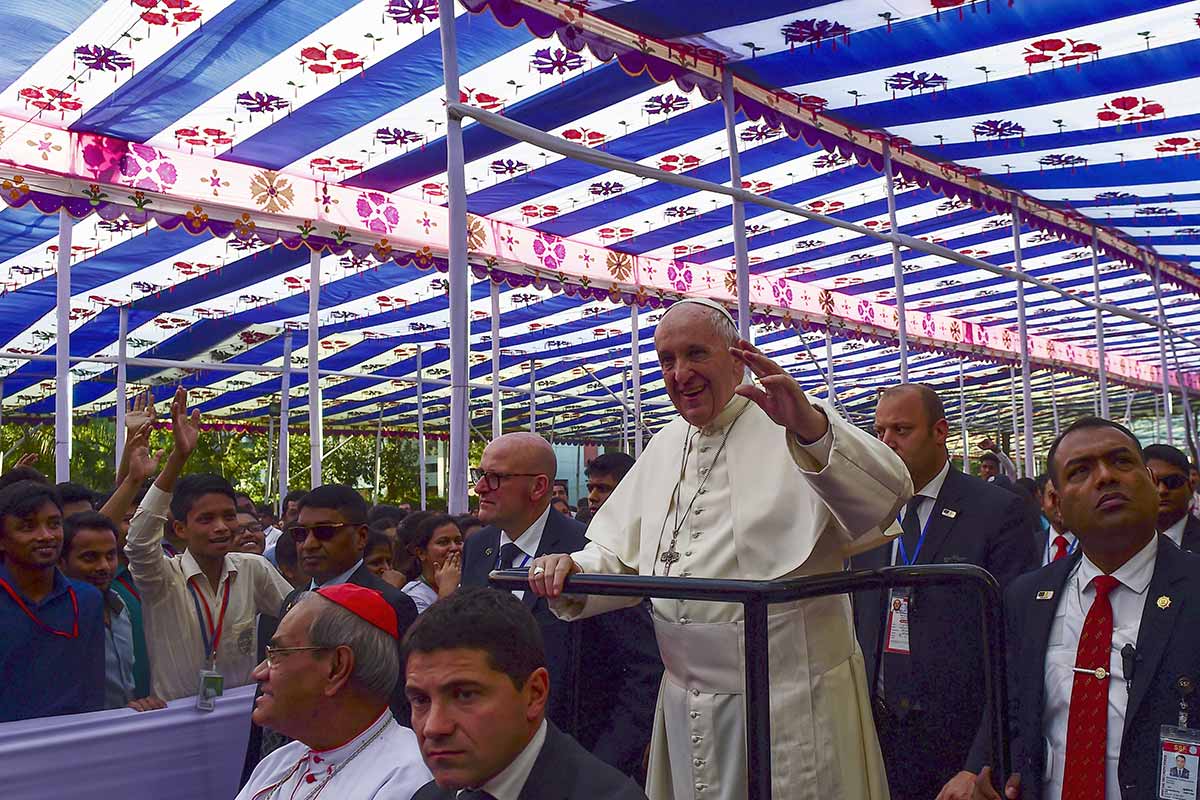Pope Francis waves to the crowd as he arrives for a meeting with young people at Notre Dame College in Dhaka on December 2, 2017. Pope Francis arrived in Bangladesh from Myanmar on November 30 for the second stage of a visit that has been overshadowed by the plight of hundreds of thousands of Rohingya refugees.