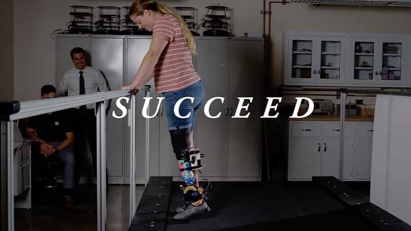 A woman works on standing on her tiptoes while testing out a powered prosthetic lower-leg. 'Succeed' text on top of the image.