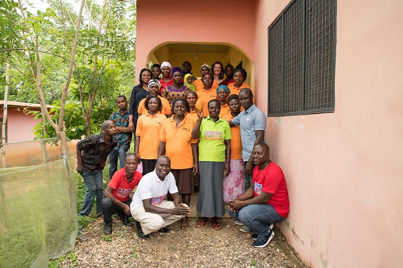 A group of people pose for a photo outside a building.