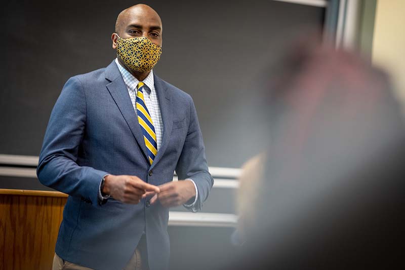 Ernest Morrell, wearing a face mask, teaching a class.