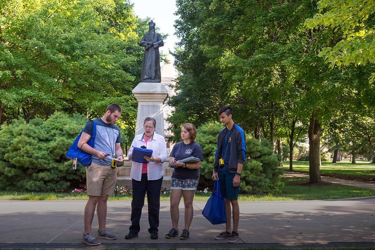 Barbara Hellenthall doing a field survey of the entire campus to catalog all the species of woody plants with students Stacie Skwarcan, Justin Peek and Ben Dowd.