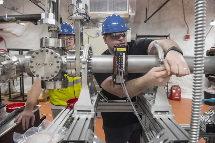 Daniel Robertson, research assistant professor, assembles the Compact Accelerator System.