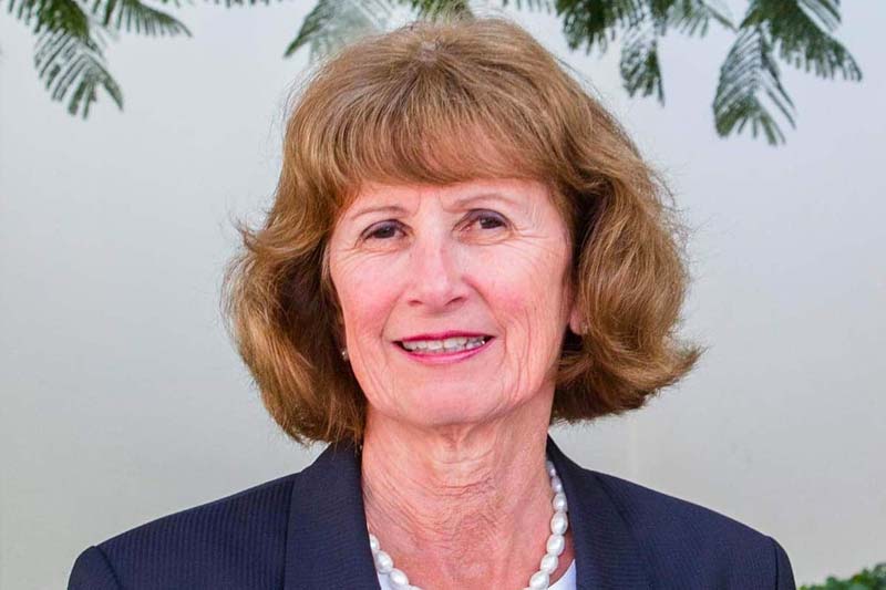 A headshot of Kathleen McChesney, a white woman wearing large white pearls and a navy suit jacket.