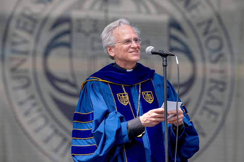 Father John Jenkins speaks at a podium.