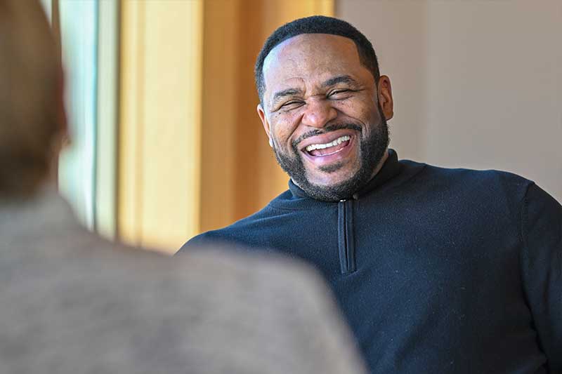 Bettis laughs while talking to another person in the chair across from him.