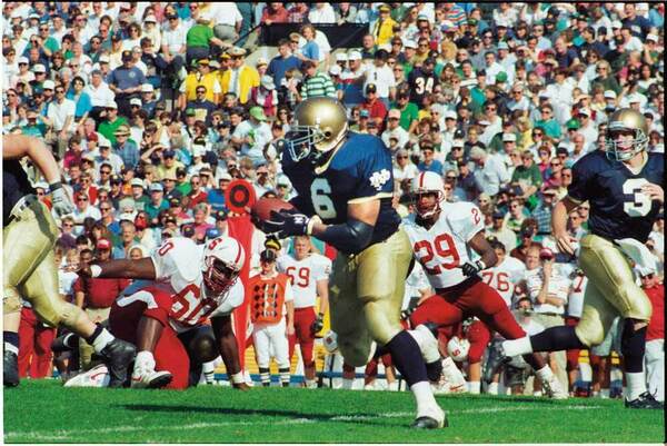 An archive photo of Bettis playing a football game in Notre Dame uniform.