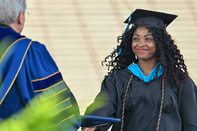 Bryanna Beamer, a Black woman and a Master of Global Affairs graduate, receives her diploma from University of Notre Dame President Rev. John I. Jenkins, C.S.C. at the 2022 Graduate School Commencement ceremony.