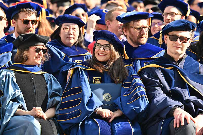 Ph.D. graduates watch and smile during the 2022 Graduate School Commencement ceremony.