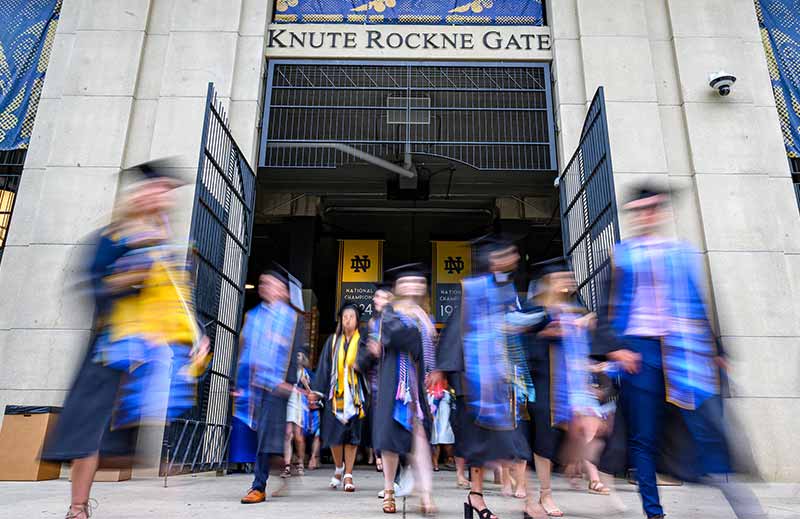 Motion blurred graduates exit Notre Dame Stadium.