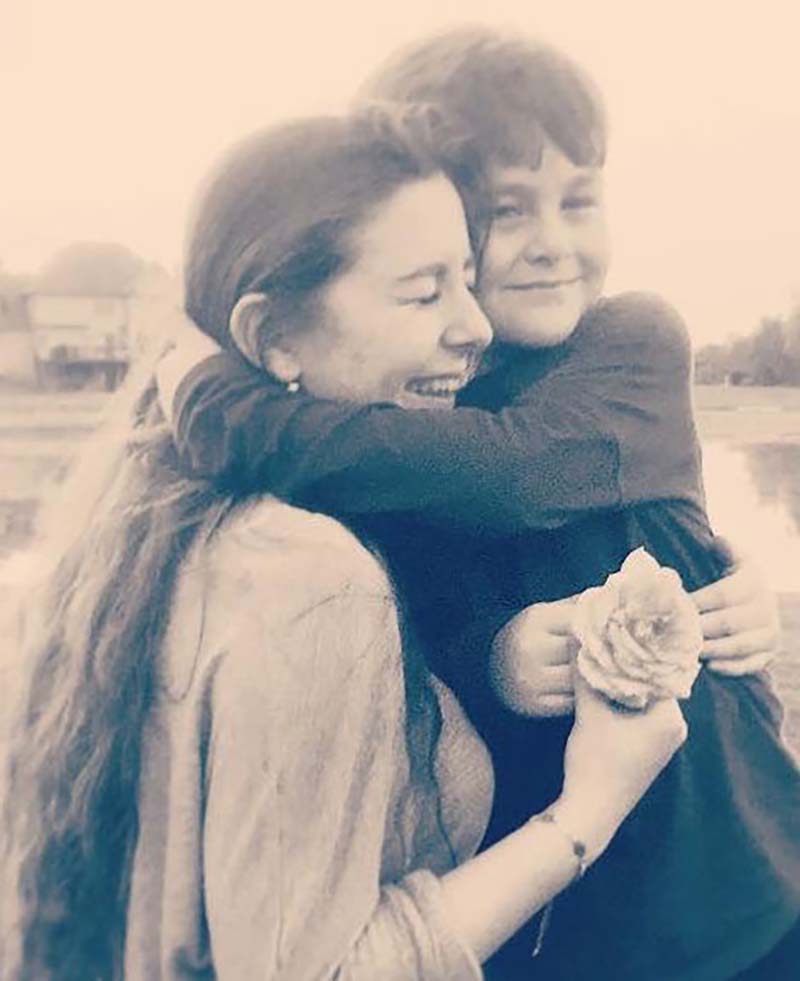 Yaseen hugs her brother in a sepia toned photo.