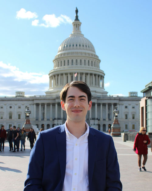 Blake Ziegler stands in front of the capital building.