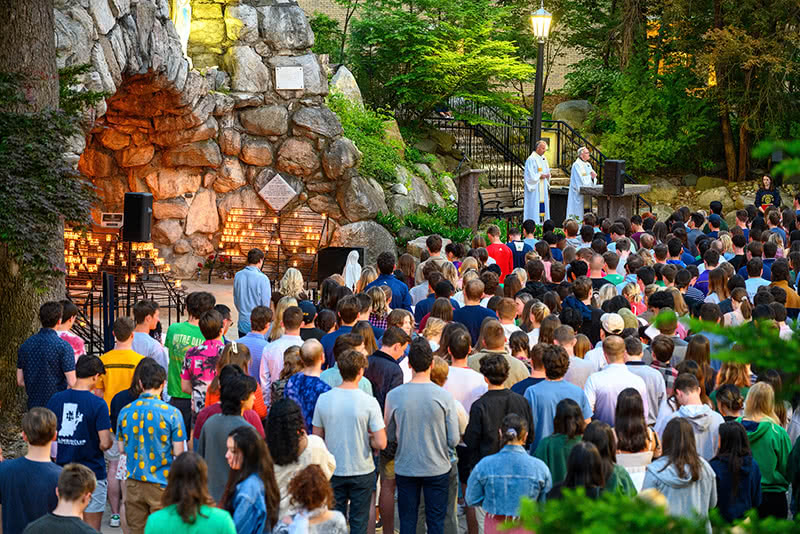 A crowd of graduating seniors gather around the grotto as Rev. Gerry Olinger, C.S.C. and Rev. John I. Jenkins, C.S.C. lead the prayer service at the Senior Last Visit to the Grotto during Senior Week 2023.