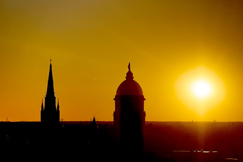 A dark silhouette of the dome and basilica at sunset.