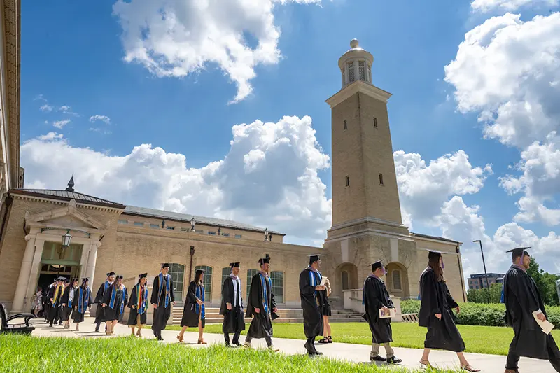 Faculty and graduates process from Walsh Family Hall of Architecture for the Diploma Ceremony on Irish Green.